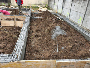 Maison à étages en phase de remblaiement de terre et compactage de la fondation thumbnail