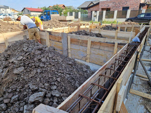 Coffrage, coulée de béton des poutres et compactage du sol et du ballast pour la fondation thumbnail