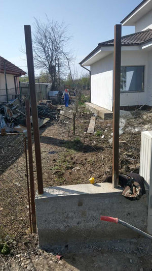 Construction d'un mur de clôture en béton et en bois pour une maison en métal thumbnail