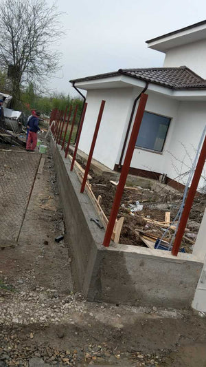 Construction d'un mur de clôture en béton et en bois pour une maison en métal thumbnail