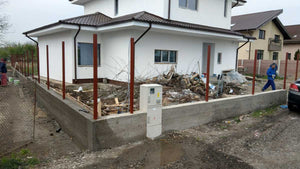Construction d'un mur de clôture en béton et en bois pour une maison en métal thumbnail