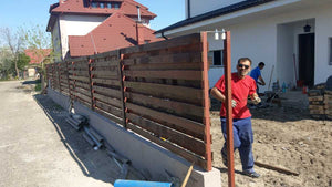 Construction d'un mur de clôture en béton et en bois pour une maison en métal thumbnail
