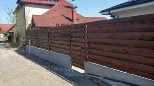 Construction d'un mur de clôture en béton et en bois pour une maison en métal thumbnail