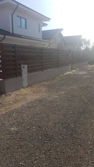 Construction d'un mur de clôture en béton et en bois pour une maison en métal thumbnail