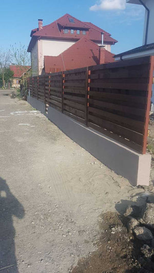 Construction d'un mur de clôture en béton et en bois pour une maison en métal thumbnail