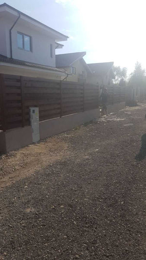 Construction d'un mur de clôture en béton et en bois pour une maison en métal thumbnail