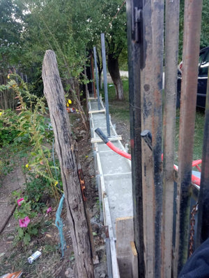 Construction d'un mur de clôture en béton avec des lattes métalliques gris anthracite, portes et allée piétonne thumbnail
