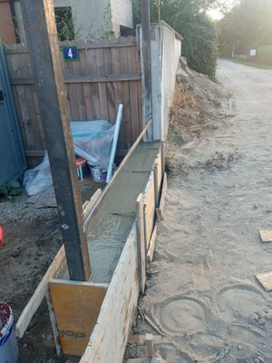 Construction d'un mur de clôture en béton avec des lattes métalliques gris anthracite, portes et allée piétonne thumbnail