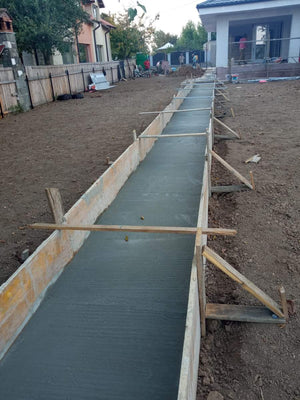 Construction d'un mur de clôture en béton avec des lattes métalliques gris anthracite, portes et allée piétonne thumbnail