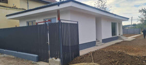 Construction d'un mur de clôture en béton avec des lattes métalliques gris anthracite, portes et allée piétonne thumbnail