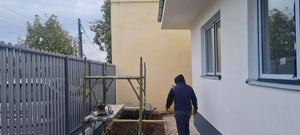 Construction d'un mur de clôture en béton avec des lattes métalliques gris anthracite, portes et allée piétonne thumbnail