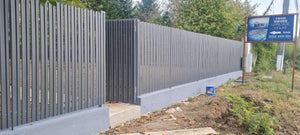 Construction d'un mur de clôture en béton avec des lattes métalliques gris anthracite, portes et allée piétonne thumbnail