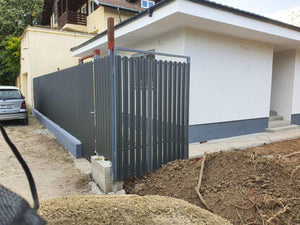 Construction d'un mur de clôture en béton avec des lattes métalliques gris anthracite, portes et allée piétonne thumbnail