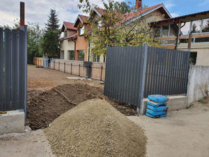 Construction d'un mur de clôture en béton avec des lattes métalliques gris anthracite, portes et allée piétonne thumbnail