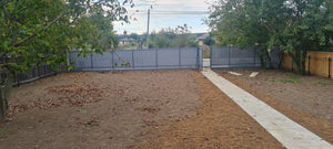 Construction d'un mur de clôture en béton avec des lattes métalliques gris anthracite, portes et allée piétonne thumbnail