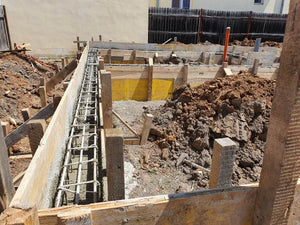 Construction d'une maison de plain-pied, coulée de béton dans les poutres de fondation thumbnail