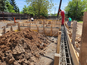 Construction d'une maison de plain-pied, coulée de béton dans les poutres de fondation thumbnail