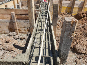 Construction d'une maison de plain-pied, coulée de béton dans les poutres de fondation thumbnail