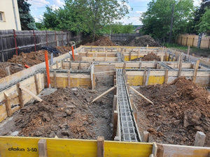 Construction d'une maison de plain-pied, coulée de béton dans les poutres de fondation thumbnail