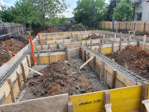 Construction d'une maison de plain-pied, coulée de béton dans les poutres de fondation thumbnail