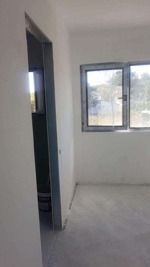Ponçage des murs intérieurs et application d'une couche d'apprêt et de mastic pour la maison à Saftica thumbnail