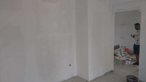 Ponçage des murs, des plafonds et application d'une couche d'apprêt avec du mastic pour le projet de maison. thumbnail