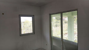 Ponçage des murs, des plafonds et application d'une couche d'apprêt avec du mastic pour le projet de maison. thumbnail