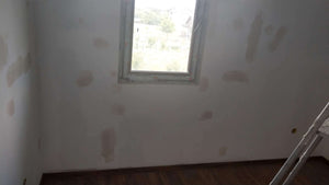 Ponçage des murs, des plafonds et application d'une couche d'apprêt avec du mastic pour le projet de maison. thumbnail