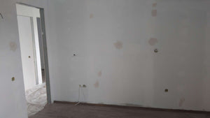 Ponçage des murs, des plafonds et application d'une couche d'apprêt avec du mastic pour le projet de maison. thumbnail