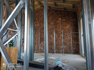 Fermeture des murs intérieurs pour une maison avec rez-de-chaussée et étage, étape de remplissage avec de la laine minérale thumbnail