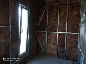 Fermeture des murs intérieurs pour une maison avec rez-de-chaussée et étage, étape de remplissage avec de la laine minérale thumbnail