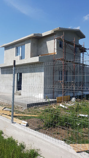 Application de mastic pour la façade d'une maison en métal à Domnesti thumbnail
