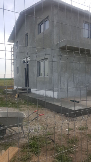 Application de mastic pour la façade d'une maison en métal à Domnesti thumbnail