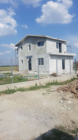 Application de mastic pour la façade d'une maison en métal à Domnesti thumbnail