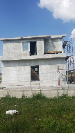Application de mastic pour la façade d'une maison en métal à Domnesti thumbnail