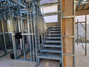 Montage d'un escalier métallique à 2 rampes avec palier et une plaque entre les niveaux thumbnail