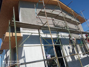 Application d'une couche d'apprêt sur les façades d'une maison métallique en construction thumbnail