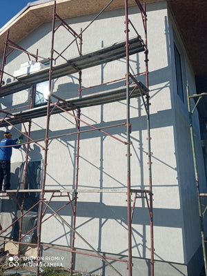 Application d'une couche d'apprêt sur les façades d'une maison métallique en construction thumbnail