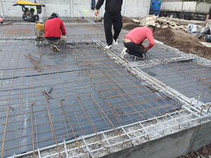 Couche de gravier, d'isolant en polystyrène et d'armature en treillis pour la fondation d'une maison métallique thumbnail