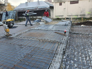 Couche de gravier, d'isolant en polystyrène et d'armature en treillis pour la fondation d'une maison métallique thumbnail