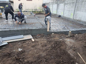 Couche de gravier, d'isolant en polystyrène et d'armature en treillis pour la fondation d'une maison métallique thumbnail