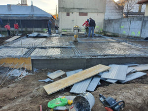 Couche de gravier, d'isolant en polystyrène et d'armature en treillis pour la fondation d'une maison métallique thumbnail